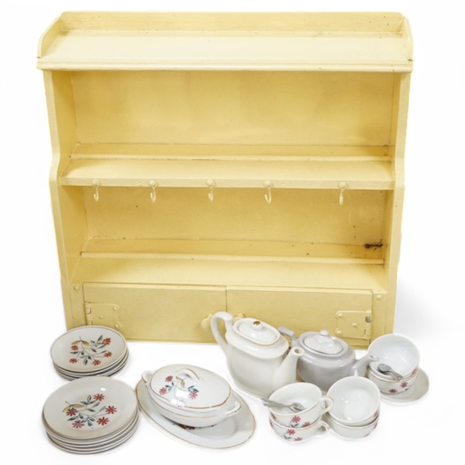 A 1930's handmade painted toy dresser with a miniature dinner service stamped ‘Foreign’ to the bases, comprising teapot, tureen, serving dish, plates, cups, etc. Condition - fair.